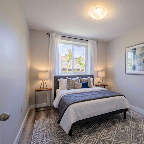a bedroom with a bed, a chair, and a painting on the wall.
