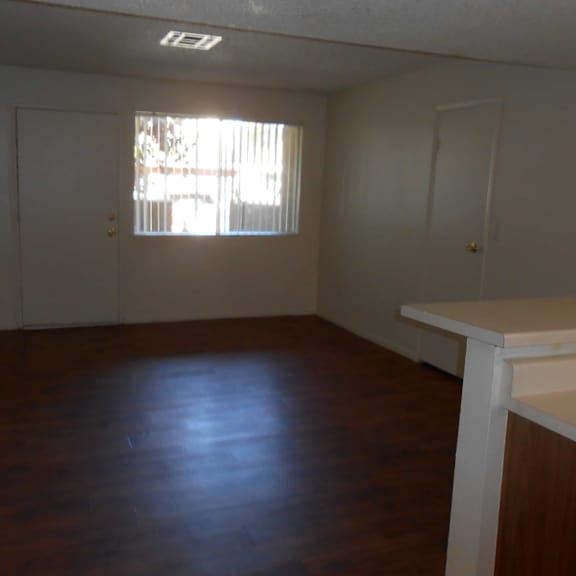 a room with a window and wooden floors.