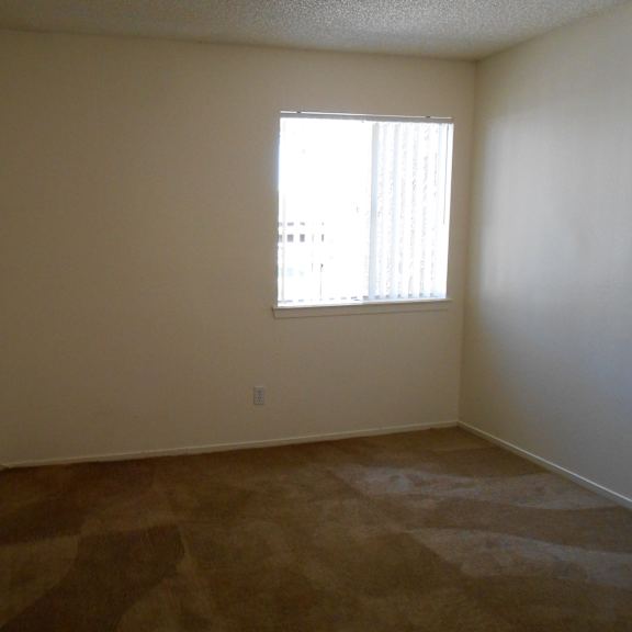 a room with a window and carpeted floor.