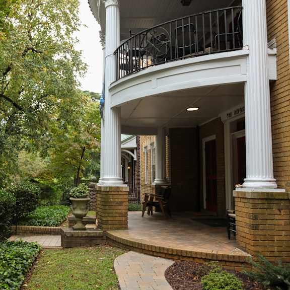 a house with a porch and a tree in front.