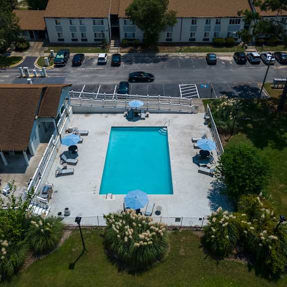 An aerial view of a pool surrounded by a parking lot and buildings. at Retreat at Savannah, Georgia