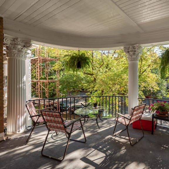 a patio with a white roof and chairs.