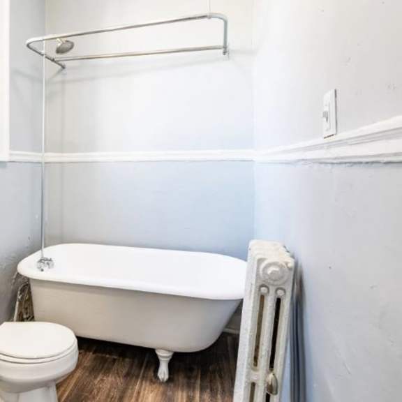 a white toilet sits next to a white bathtub in a bathroom.