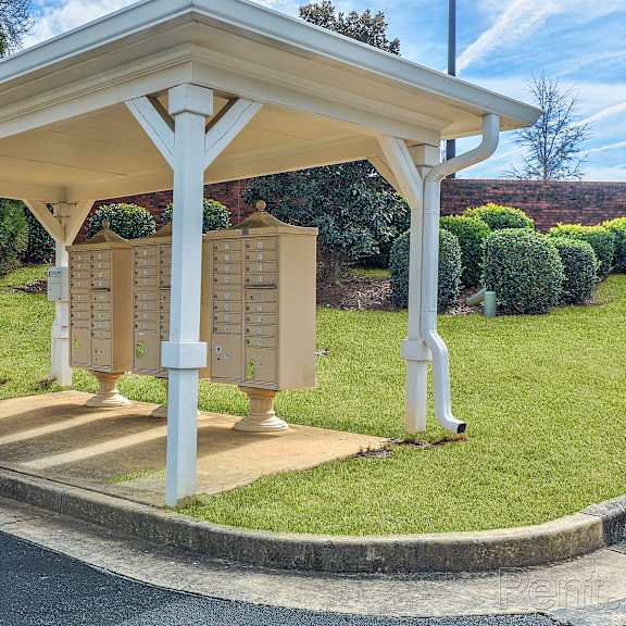 a small pavilion with a roof and a mailbox on the side.