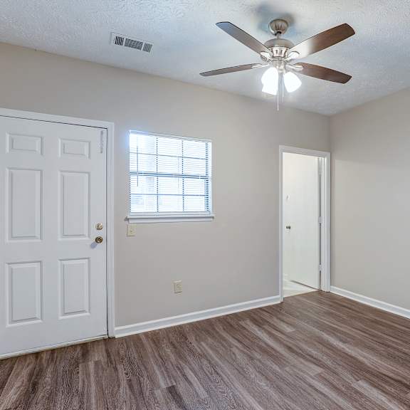 a room with a ceiling fan and a door.