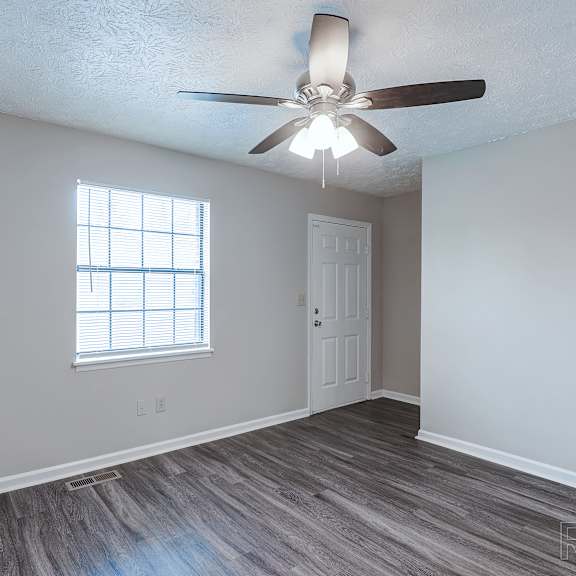 a room with a ceiling fan and a window.