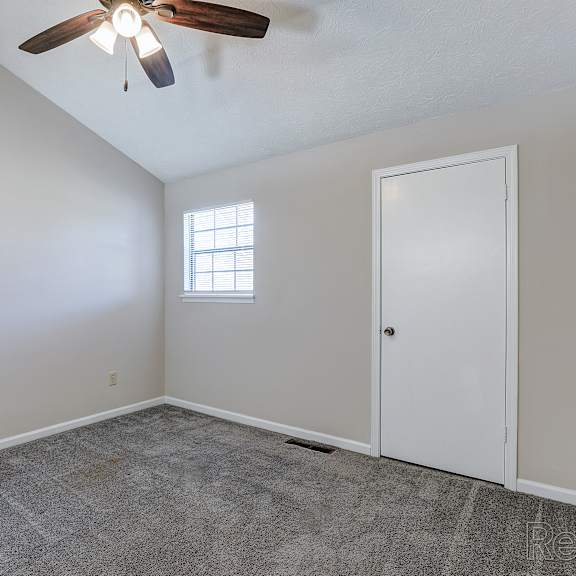 a room with a ceiling fan and a window.