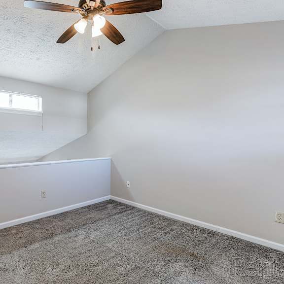 a room with a ceiling fan and a window.