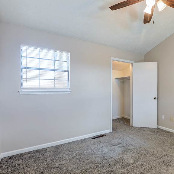 a room with a ceiling fan and a window.