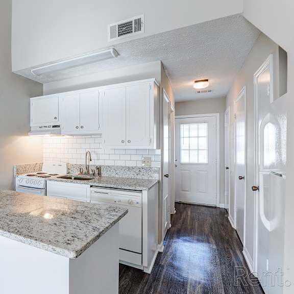 a kitchen with white cabinets and a granite countertop.