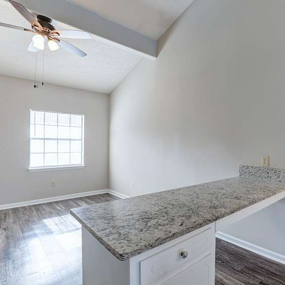 a kitchen with a marble countertop and a ceiling fan.