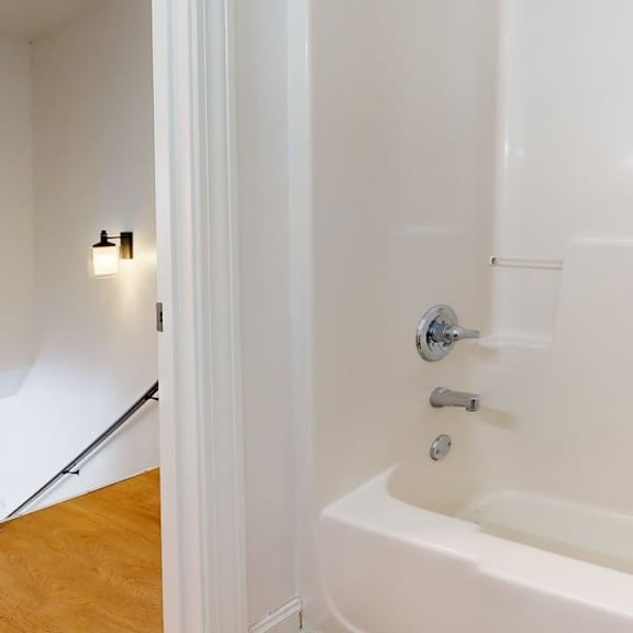 a white bathtub with a silver faucet and a silver handle.