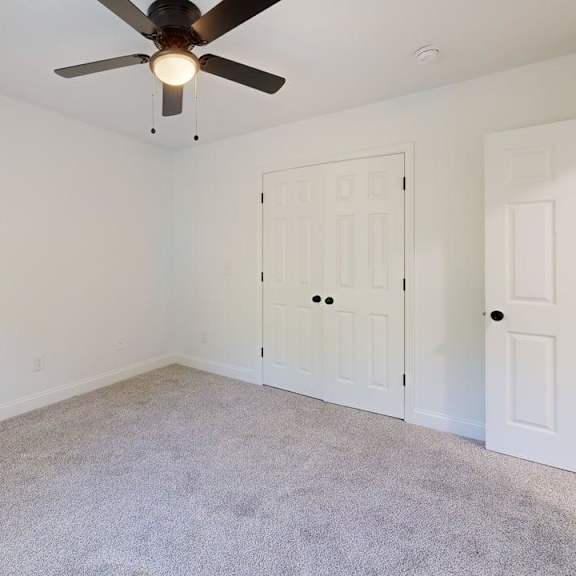 a room with a ceiling fan and two doors.