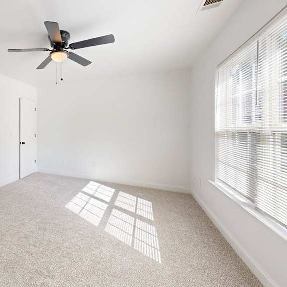 a room with a ceiling fan and a carpeted floor.