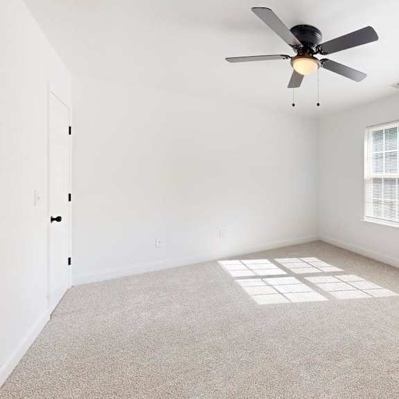 a room with a ceiling fan and a window.