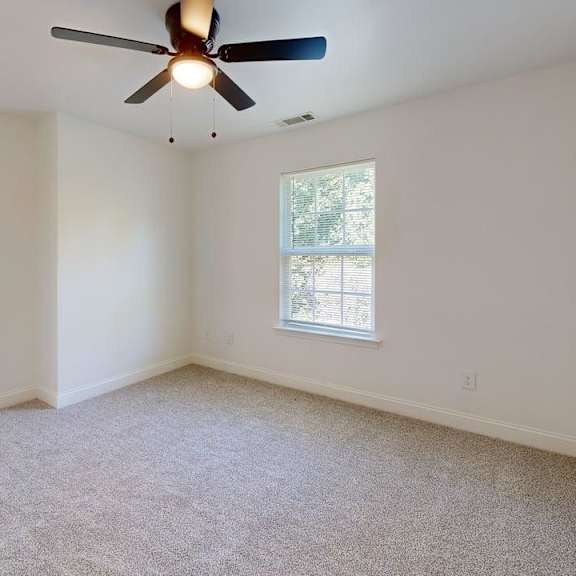 a room with a ceiling fan and a window.