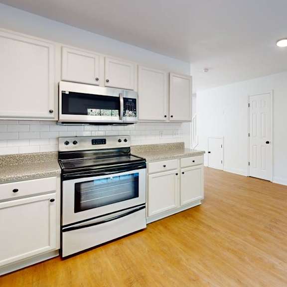 a kitchen with white cabinets and a stainless steel oven.