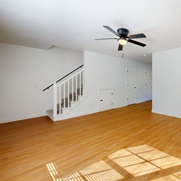 a room with a ceiling fan and a wooden floor.