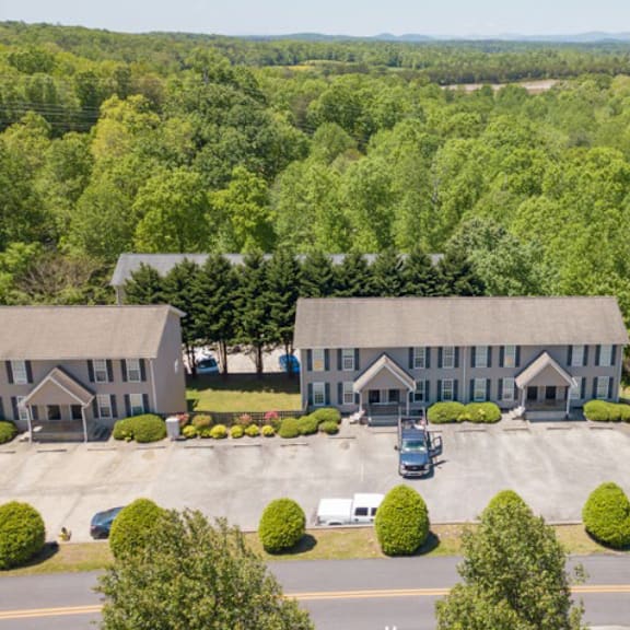 a large building surrounded by trees and a parking lot.