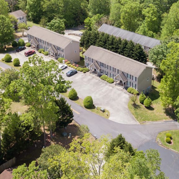 a large building surrounded by trees and a parking lot.