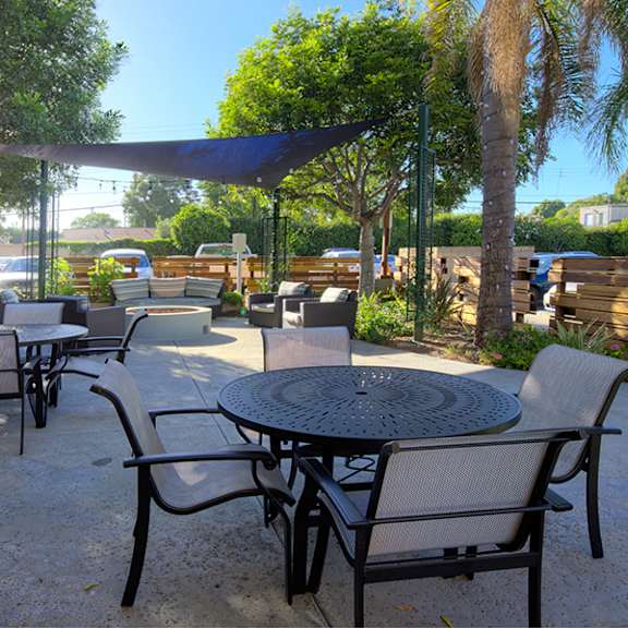 a patio with tables and chairs under a canopy.
