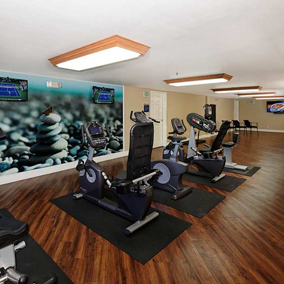 a gym with exercise equipment and a tv.