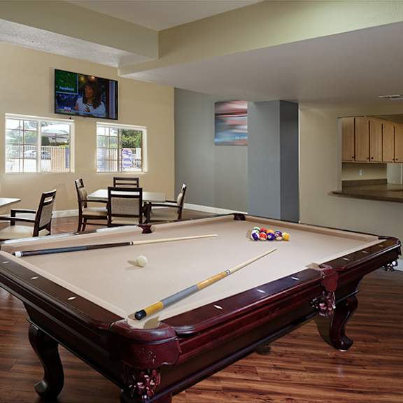 a pool table is in the middle of a room with chairs around it.