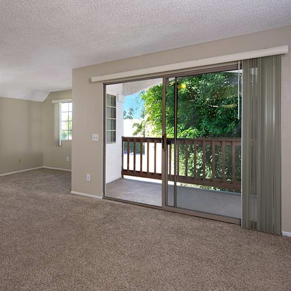 a room with a sliding glass door leading to a balcony.