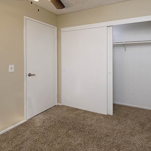 a room with a carpeted floor and two white doors.