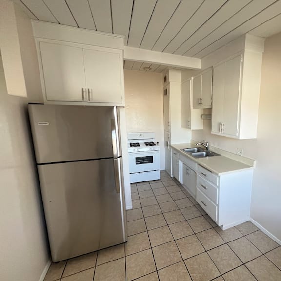 a kitchen with white cabinets and a stainless steel refrigerator.