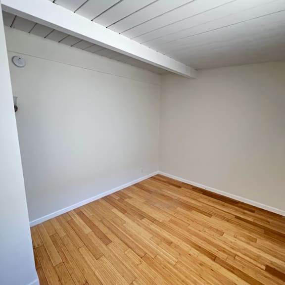 a room with wooden flooring and white walls.