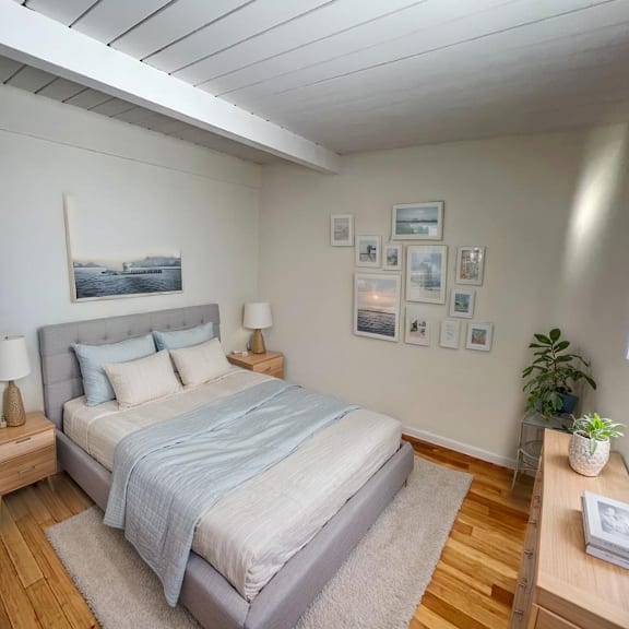 a bedroom with a bed, nightstands, and pictures on the wall.