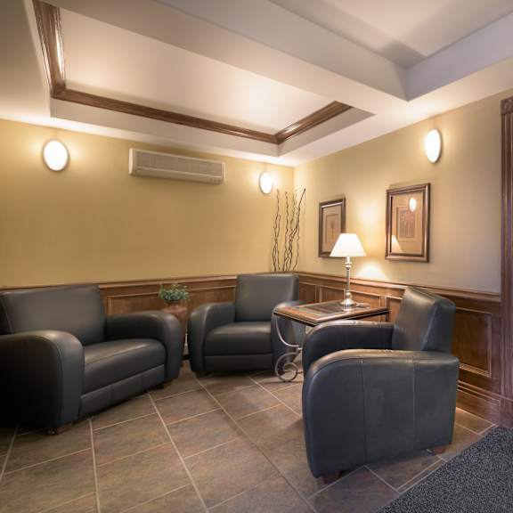 a room with a brown floor and a white ceiling with a table and chairs.