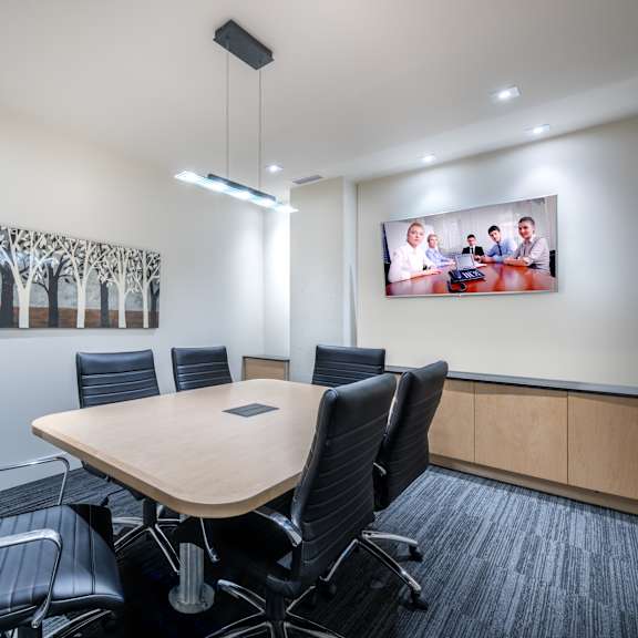 a conference room with a large table surrounded by chairs.
