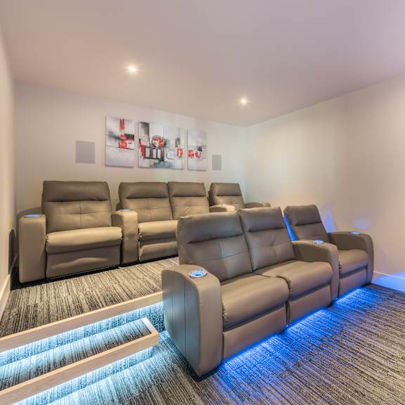 a row of leather recliner chairs are lined up in a room with a carpeted floor.