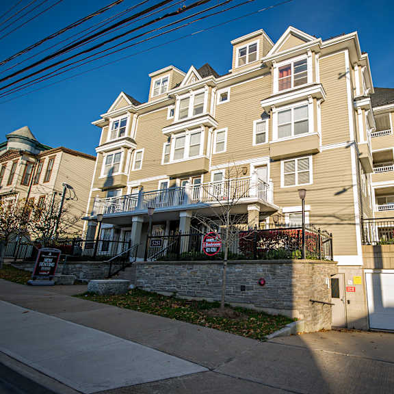 a large, multi-story building with a gated entrance and a "no trespassing" sign in front.