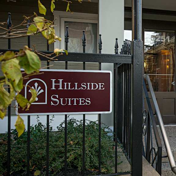 a sign for hillside suites is displayed in front of a building.