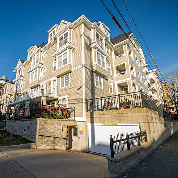 a large, multi-story building with a beige facade and black railings.