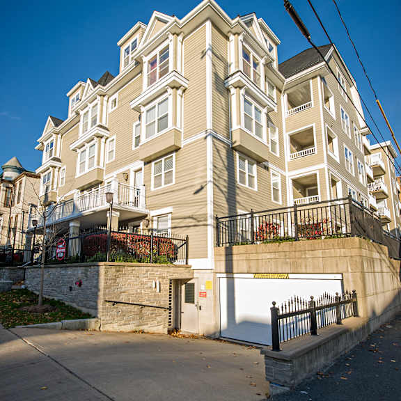 a large, multi-story building with a white fence in front.
