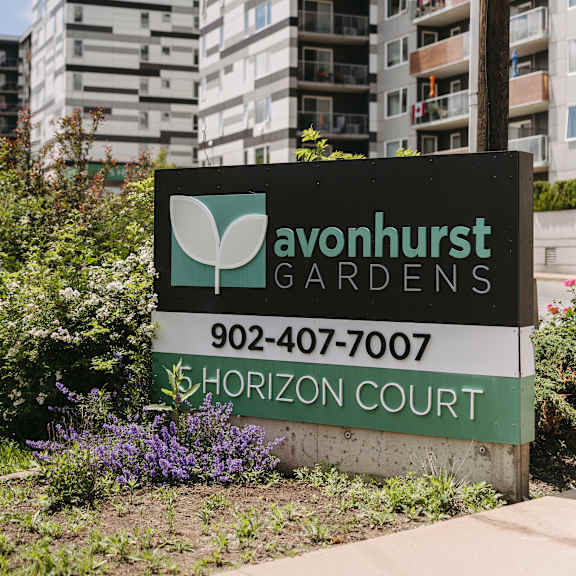 a sign for avonhurst gardens in front of apartment buildings.