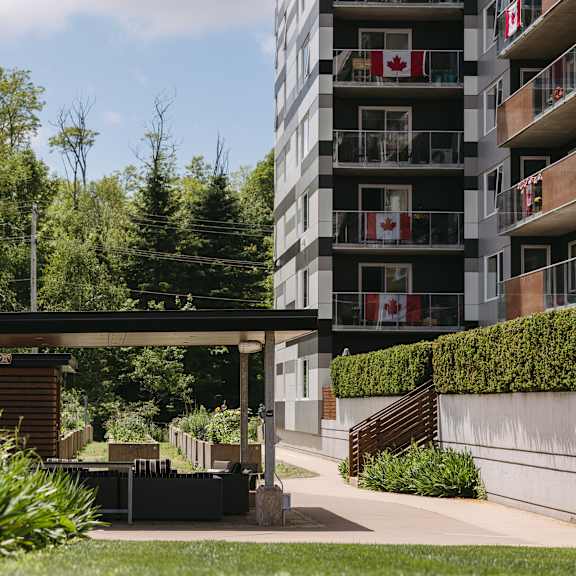 a modern building with balconies and canadian flags on them.