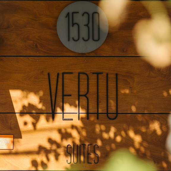 a sign with the number 1530 and the word vertu is displayed on a wooden background.