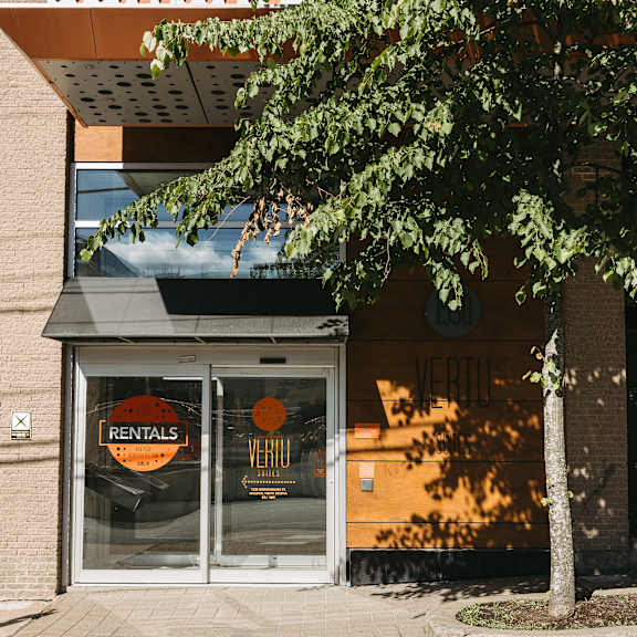 a tree in front of a building with a sign that says rentals.
