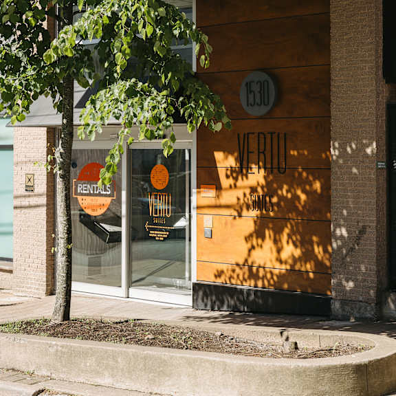 a tree is in front of a building with a sign that says rentals.