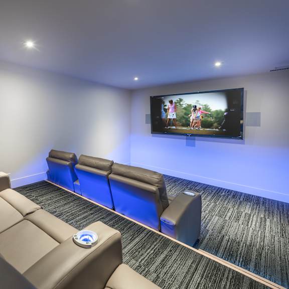 a home theater with a large screen and comfortable seating.