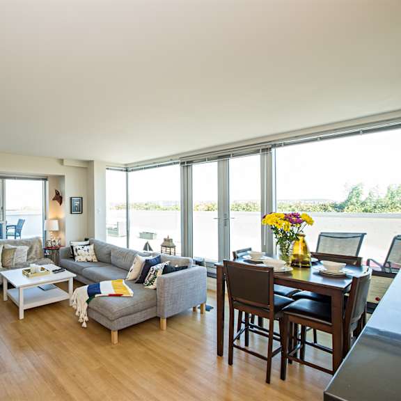 a living room with a grey couch and a wooden floor.