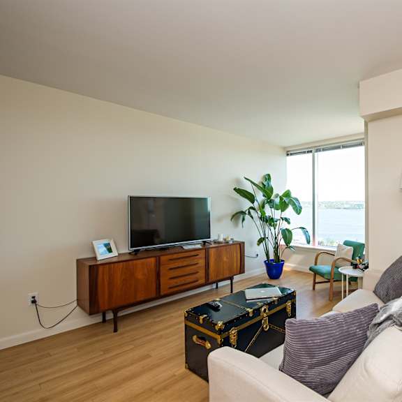 a living room with a white couch and a wooden cabinet.