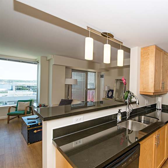 a kitchen with a black counter top and wooden cabinets.