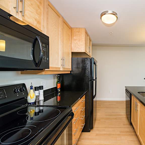 a kitchen with black countertops and wooden cabinets.
