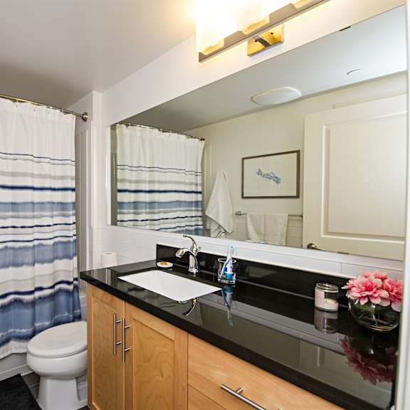 a bathroom with a toilet, sink, and shower curtain.